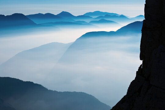 Mountain peaks rising above a thick sea of fog represent a nature landscape, offering adventure and tourism exploration within the Julian Alps Natural Park, Alba Valley, Friuli Venezia Giulia, Italy..