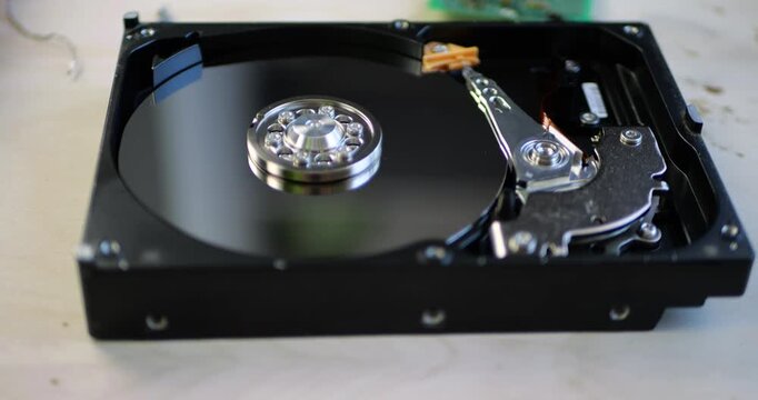 Hard drive reveals intricate internal components. Engineers analyze technology for data storage solutions. Precision mechanics showcase innovation in hardware design. Essential for modern computing