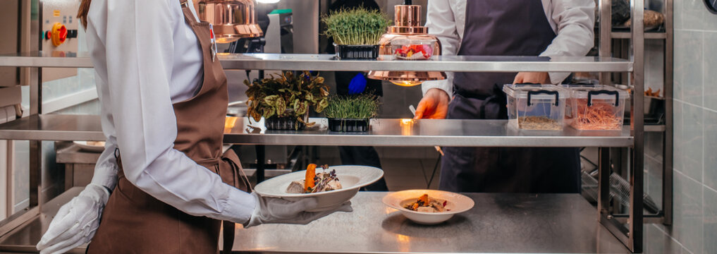Restaurant Kitchen Staff Serving Gourmet Dish During Service