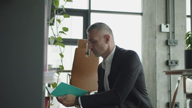 Mature businessman search in office, footage. Business boss man. Business success. Successful business. Entrepreneur searching for notes. Office manager man. Businessman in suit look for notes