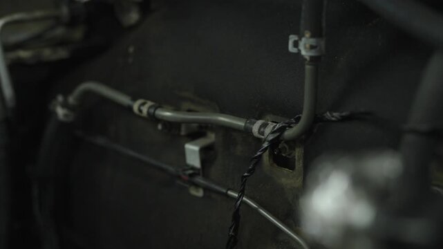 Metal vacuum line tubes secured with clips on engine firewall.