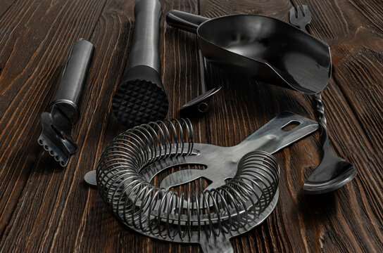 Professional matte black cocktail bartender tool set on dark wooden background