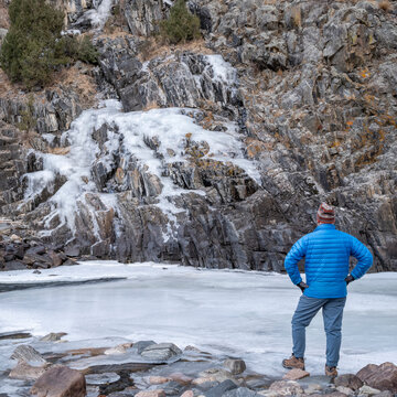 senior male hiker in a canyon of mountain river in winter scenery - Poudre River at Little Narrow above Fort Collins, Colorado