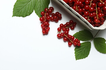 Redcurrant berries with green leaves on a white background. © Pixora ST 