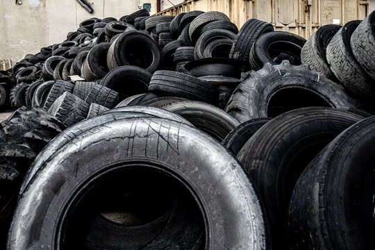 Large pile of discarded rubber tires at a recycling yard