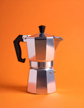 Close-up of moka pot coffee maker on bright orange background.