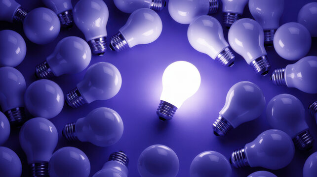 A single glowing light bulb standing out among many unlit bulbs on a purple background.