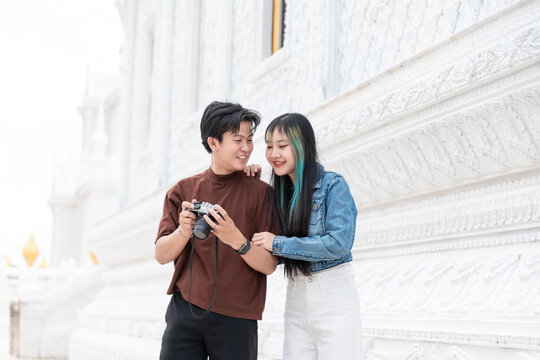 Romantic Asian couple embracing outdoors while sightseeing