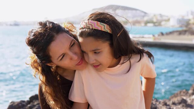 Happy mother having fun with daughter on the beach - Mom and female child having tender moment outdoor - Family, love and holiday concept