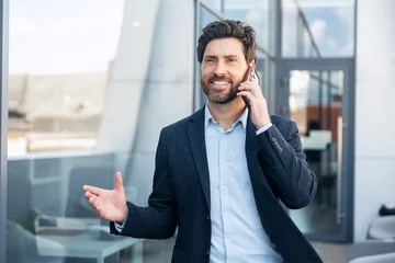 Professional businessman talking on mobile phone outdoors © Maria Vitkovska