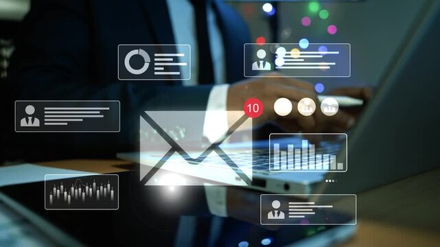 Businessman using a laptop with hologram email profile and chart icons floating above the screen, Holographic online communication data analytics and digital work in a modern office