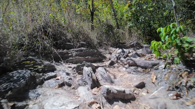 Low angle fast walk over rough rocky terrain in nature