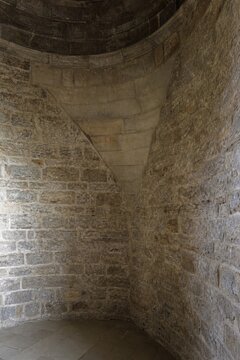 Interior of a round stone tower, corner where masonry walls curve inward to support the ceiling.