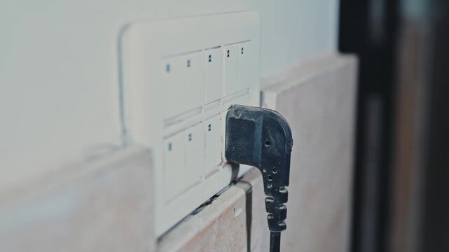 Close Up of Electrical Plug Connected to Wall Socket Switch Board