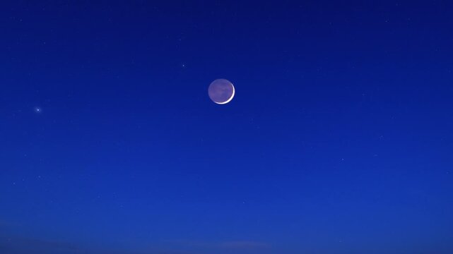 Blue hour time with crescent Moon, stars and planets on a twilight sky.