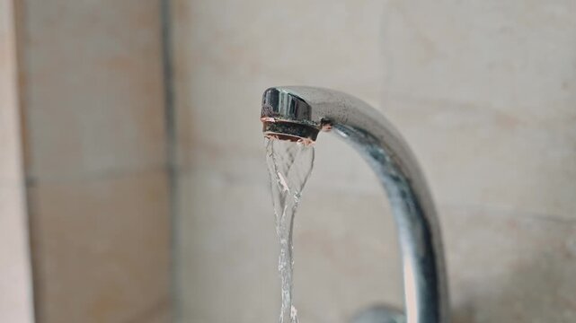 Close Up of Running Water from Rusty Kitchen Faucet with Mineral Deposits
