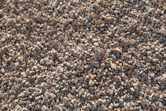Crushed stone and gravel texture close up background top view. The aggregate material creates a uniform raw texture for construction projects