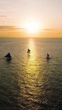 Sunset Sailing in Boracay. Scenic landscape of boats running over the sea. Philippines. Vertical view.