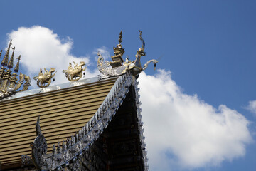 The eaves of a beautifully decorated Thai temple against a backdrop of the sky. © jamroenjaiman