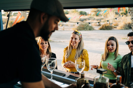 Group of happy friends making order in food truck
