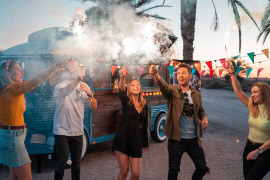 Friends having fun with fireworks near food truck