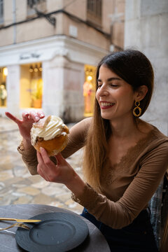 Woman enjoying sweet pastry with whipped cream