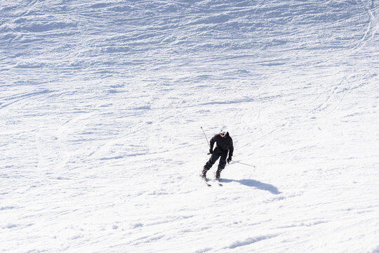 A person skiing down a snowy slope in winter. Copy space