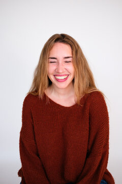 Woman Smiles With Closed Eyes in a Studio Setting During Daylight