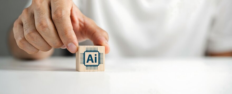 Hand holding wooden block with AI icon. Artificial intelligence concept for tech business.