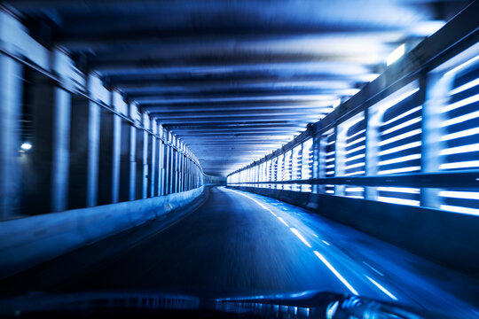 Driving Through a Blue Lit Tunnel in an Urban Setting