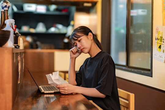 レシートを見てパソコンに入力する女性