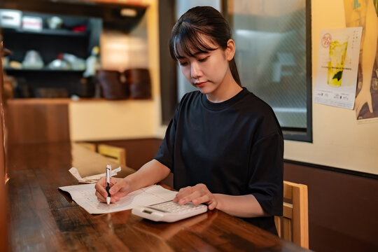 電卓をで計算する女性