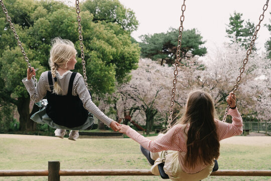 Two girl swinging in the park in Kyoto