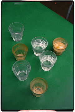 Six glasses on a table: two with water, two with espresso, two empty.
