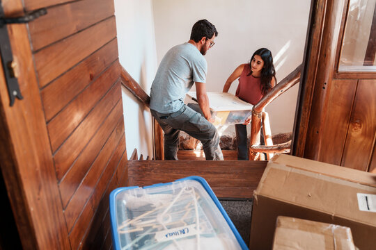 Couple Carrying Boxes While Moving In 