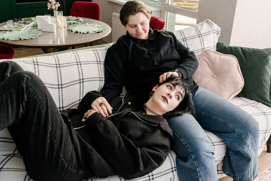 Women are relaxing on the couch enjoying each other's company.