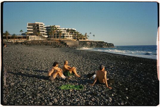 Friends enjoy a sunny, quiet day on a rocky beach in La Palma.