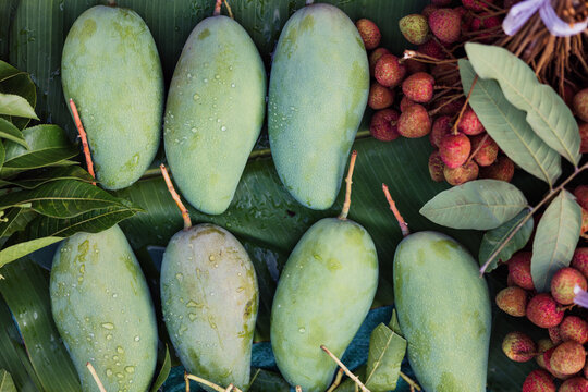 Fresh Green Mangoes and Lychees on Banana Leaves