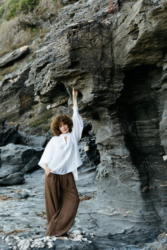Woman posing in relaxed fashion clothing by rocky cliff