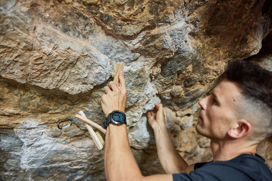 Climber prepares to scale a rock wall in outdoor setting