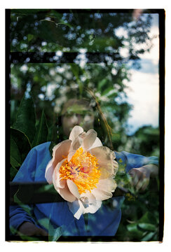 A woman's face layered with a peony in double exposure