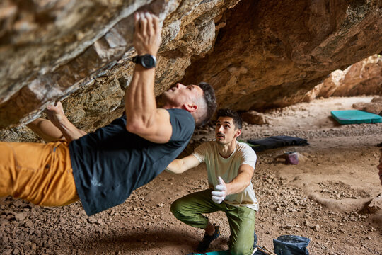 Rock climbing practice takes place in a cave with two climbers