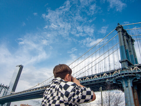 captures New York skyline with Brooklyn Bridge from waterfront

