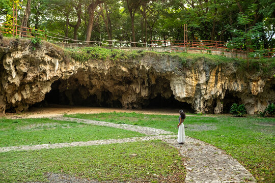 Woman photographing Taino petroglyphs in cave