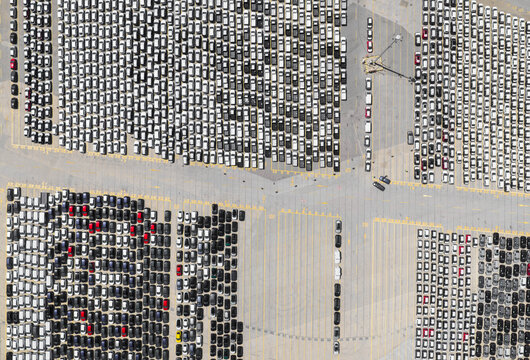 New cars parked at a large port terminal