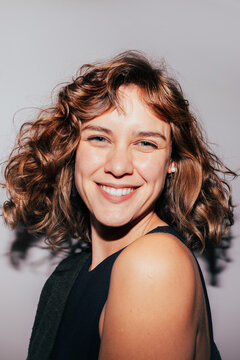 Smiling woman with curly hair and earrings