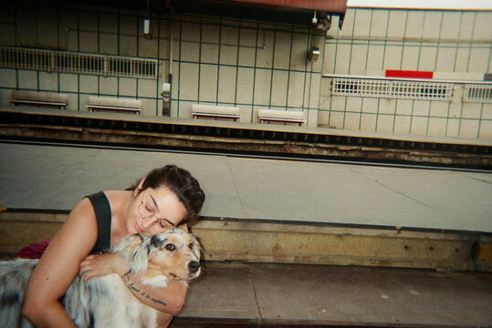 Woman Hugging Dog at Train Station