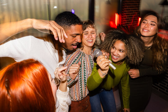 Friends enjoying a lively indoor karaoke night