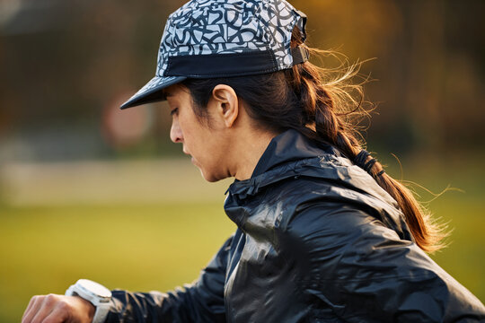 Female Athlete Reviewing Running Data Mid Training Session