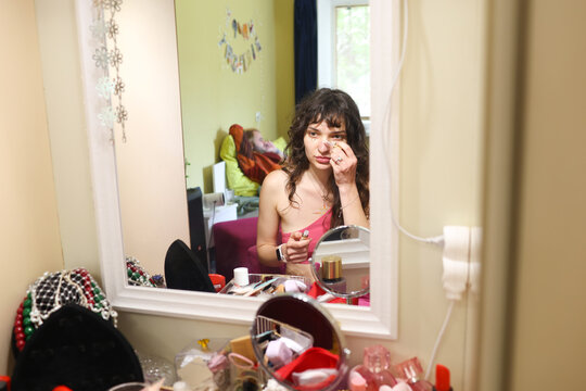 young woman doing makeup at home